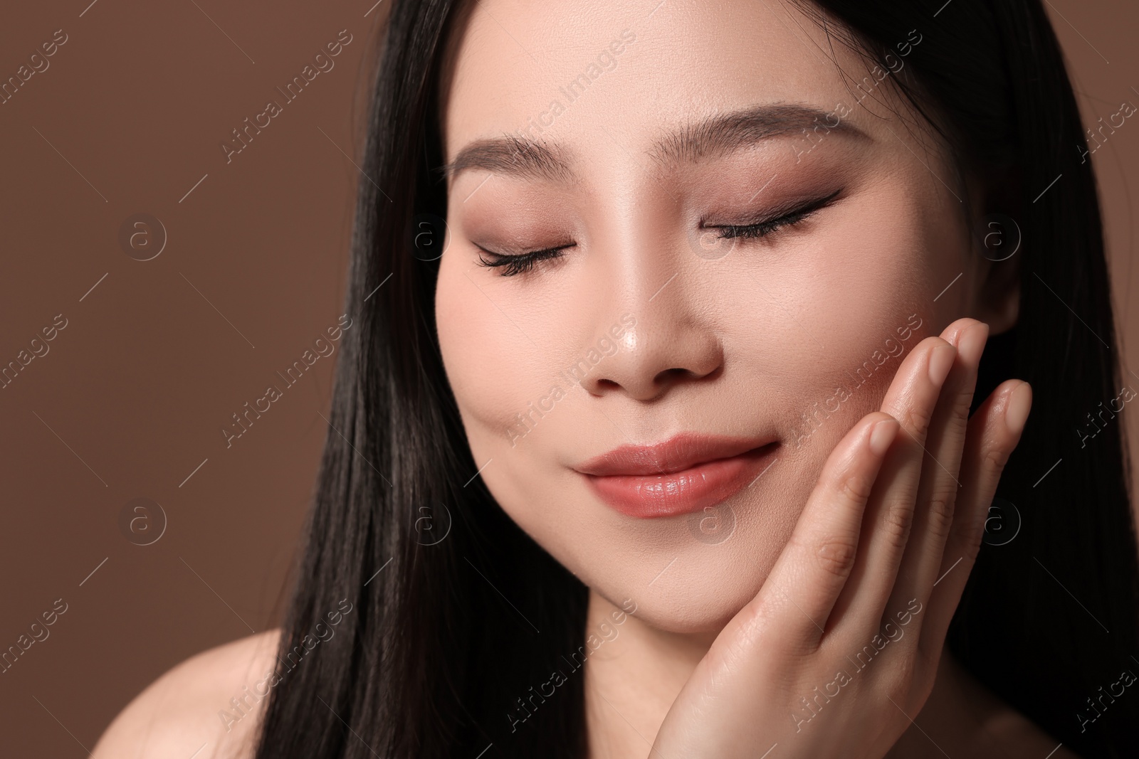 Photo of Portrait of beautiful woman on brown background, closeup