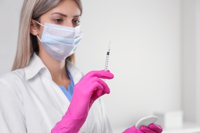 Photo of Doctor holding syringe with vaccine in hospital