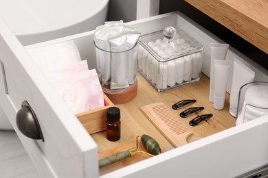 Photo of Open cabinet drawer with tampons and feminine hygiene products