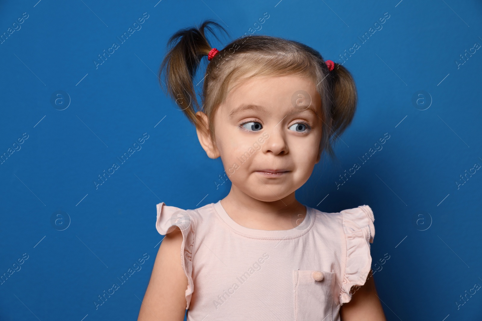 Photo of Portrait of cute little girl on blue background