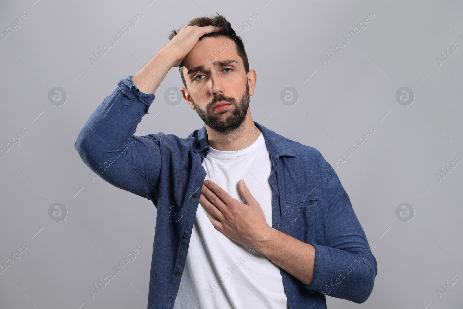 Photo of Man suffering from cold on grey background