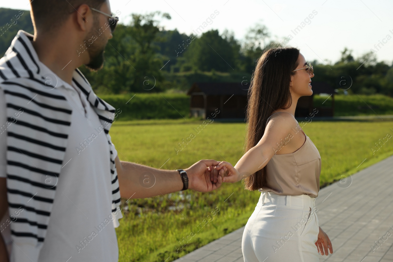 Photo of Romantic date. Beautiful couple walking in park on sunny day