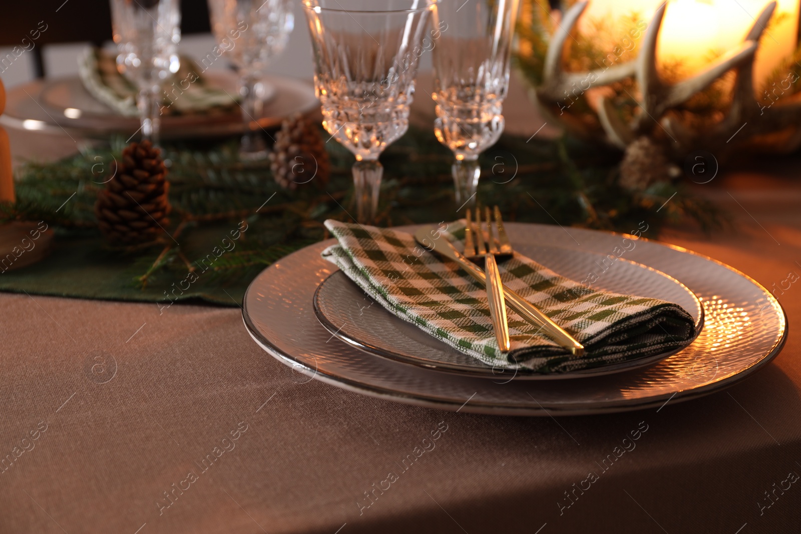 Photo of Christmas place setting with festive decor on table, closeup