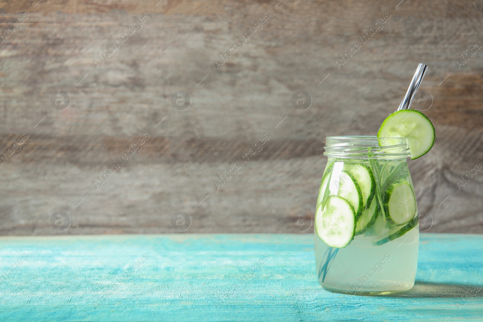 Photo of Natural lemonade with cucumber in jar on wooden table