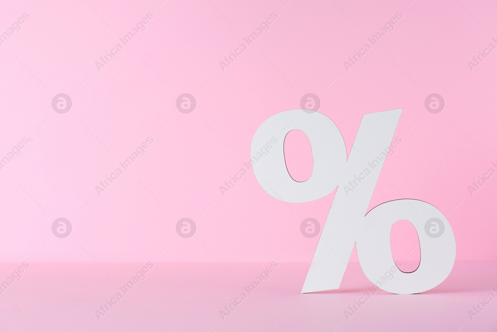 Photo of Paper percent symbol cutout on pink background. Space for text