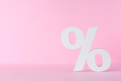 Paper percent symbol cutout on pink background. Space for text