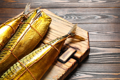 Tasty smoked fish on wooden table, closeup