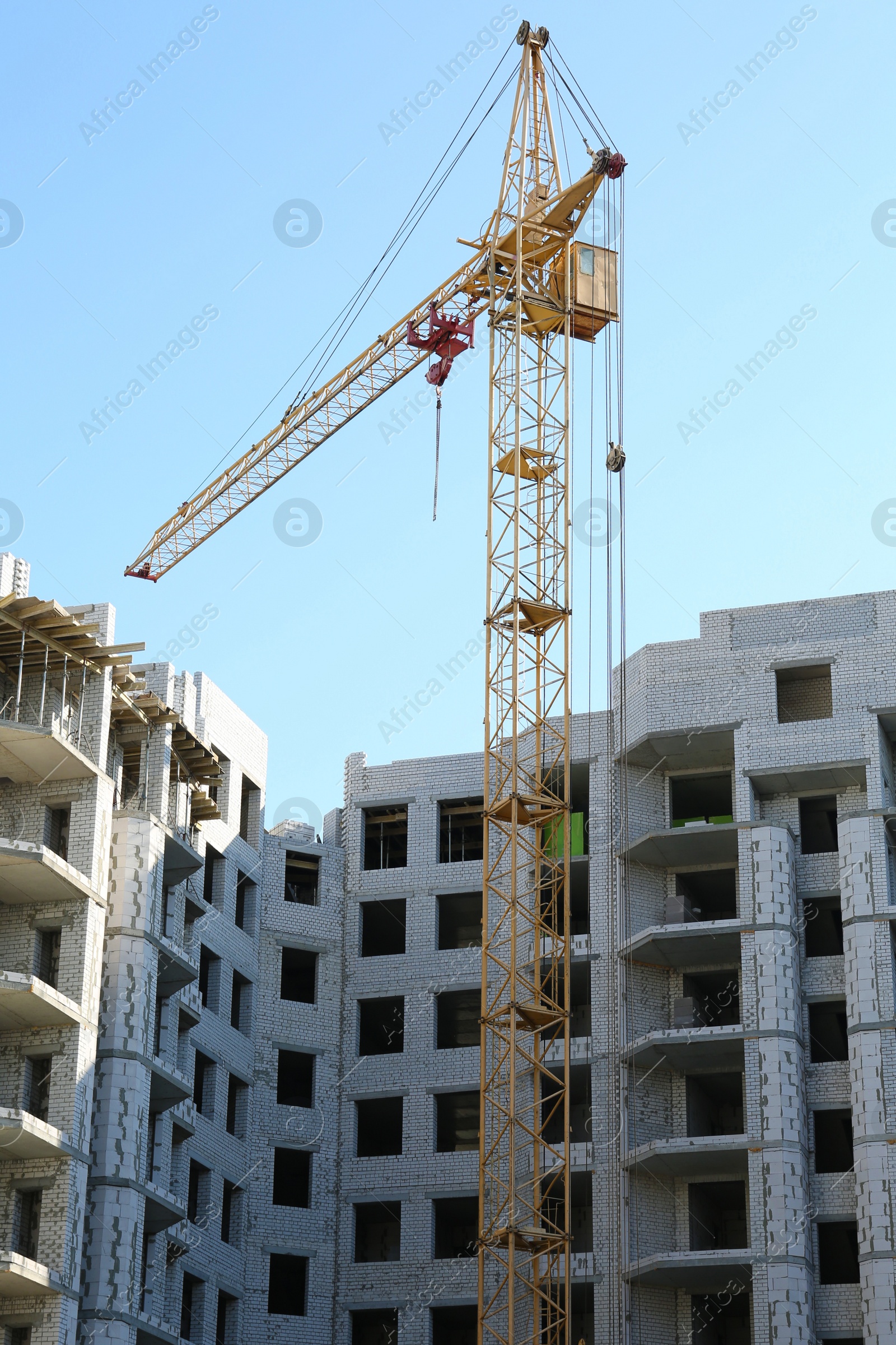 Photo of Construction site with tower crane near unfinished building