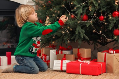 Little child decorating Christmas tree at home
