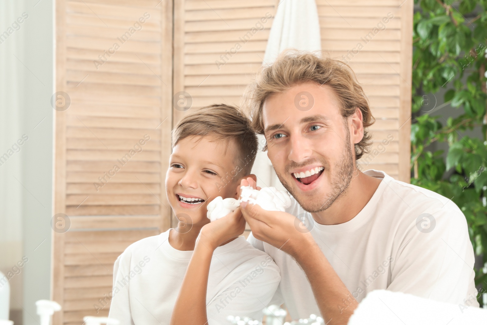 Photo of Father and son applying shaving foam in bathroom