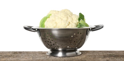 Metal colander with cauliflower on wooden table against white background