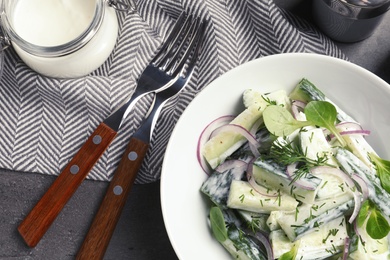 Photo of Plate with creamy cucumber salad served on table, top view