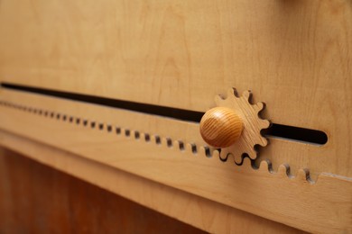 Photo of Wooden sliding maze on wall, closeup. Montessori toy