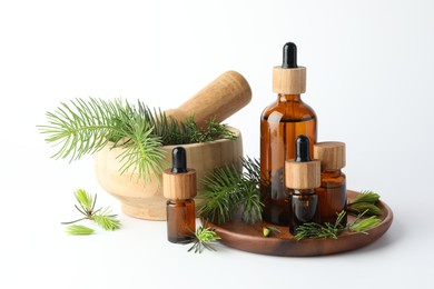 Photo of Aromatherapy. Different essential oils, fir twigs, mortar and pestle on white background