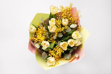 Bouquet of beautiful spring flowers on light grey background, top view