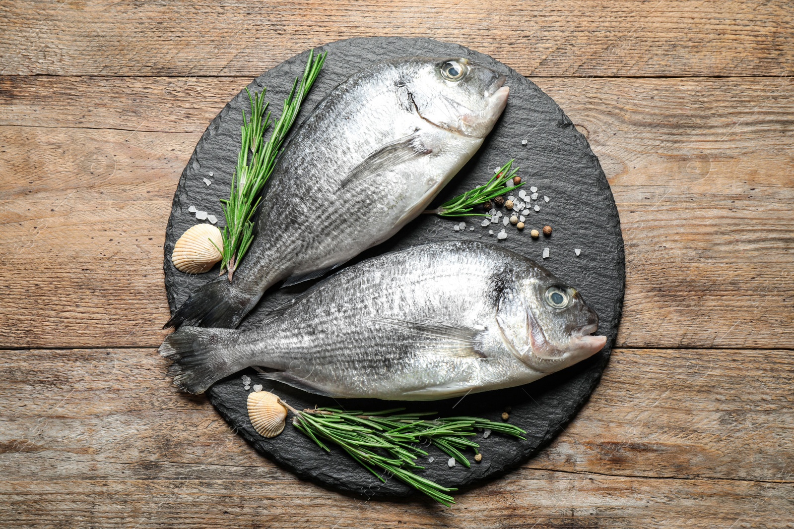 Photo of Raw dorada fish on wooden table, top view