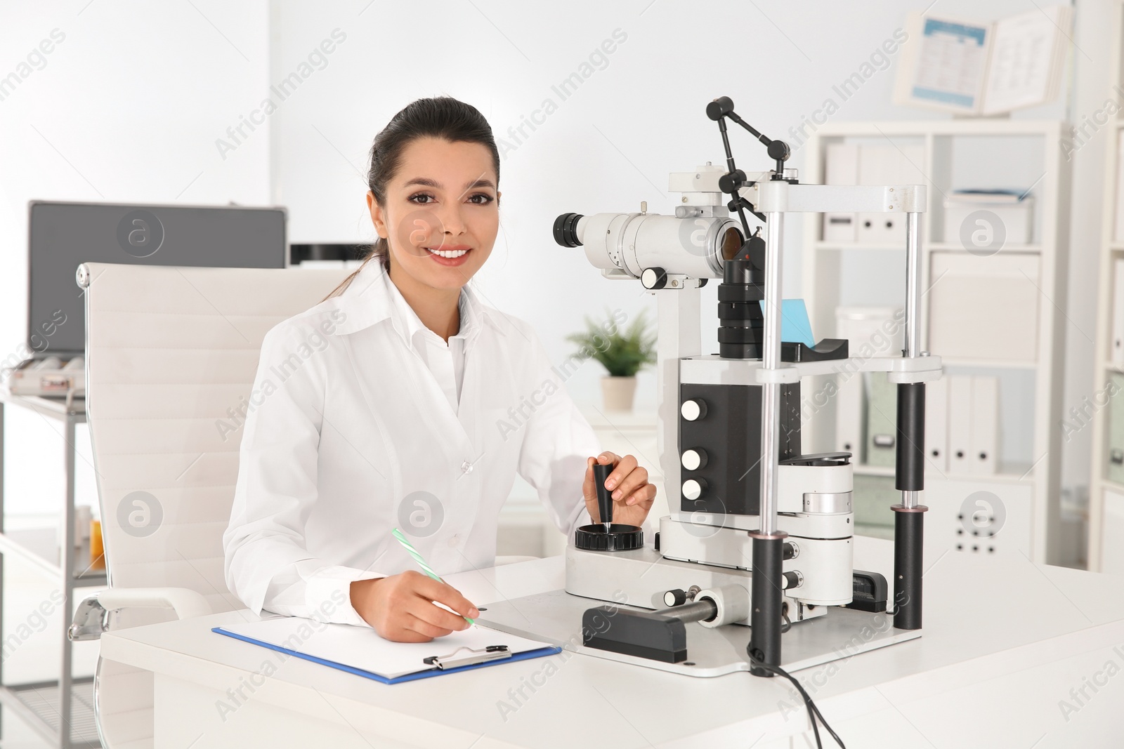 Photo of Female children's doctor with ophthalmic equipment in office