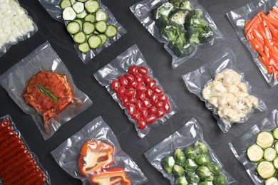 Photo of Flat lay compositiondifferent food in vacuum packings on dark grey table