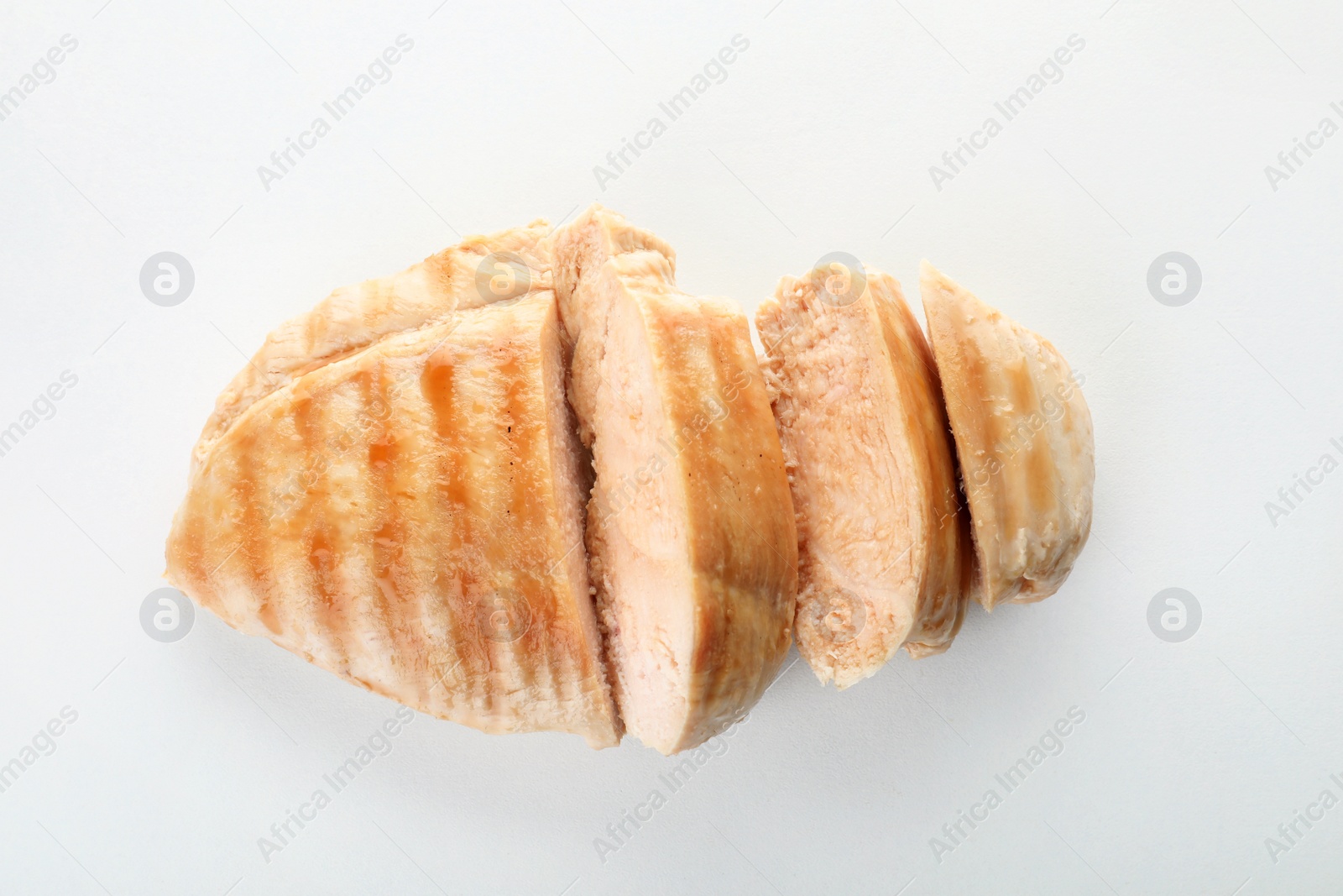 Photo of Delicious cut grilled meat on white background, top view