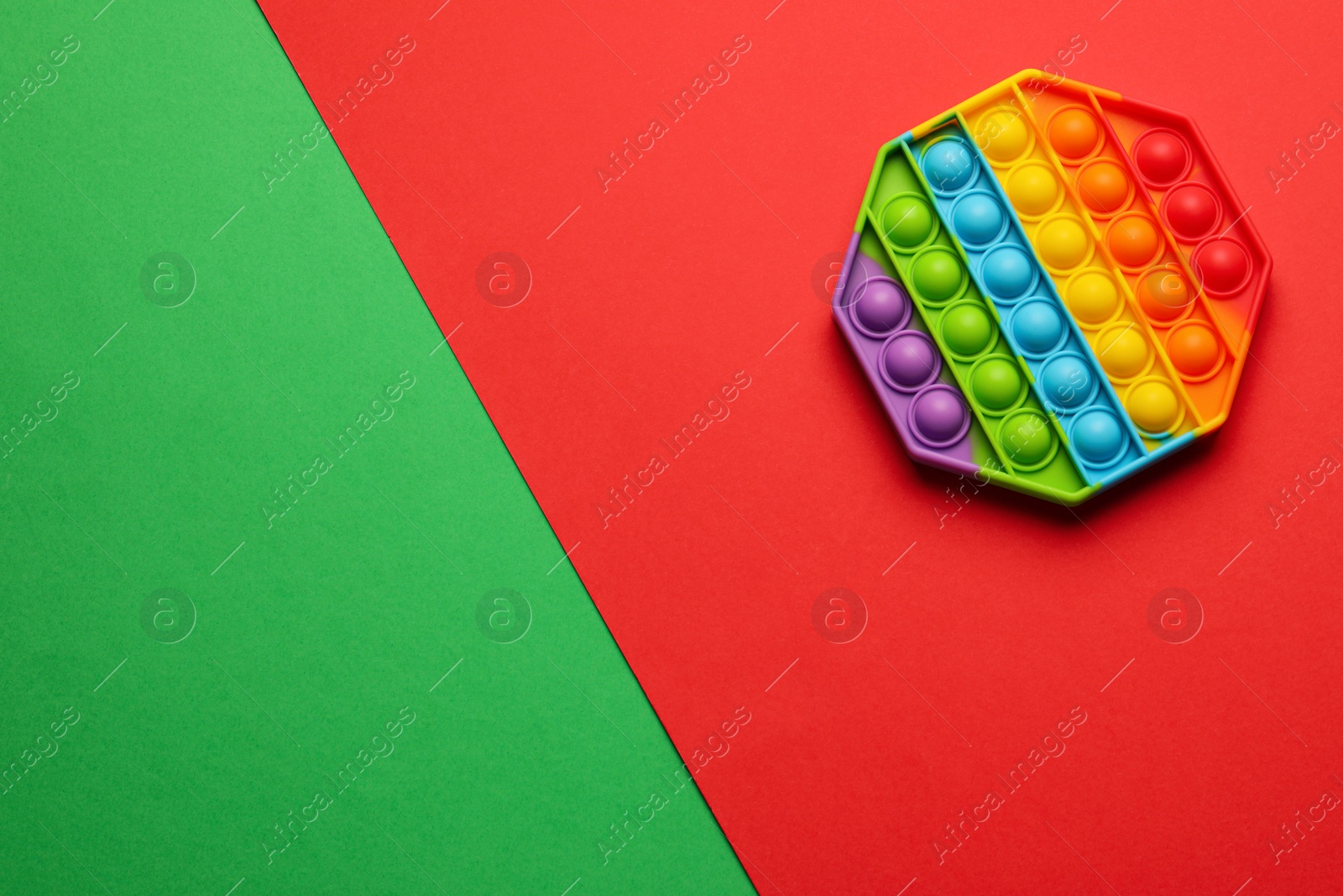 Photo of Rainbow pop it fidget toy on color background, top view. Space for text