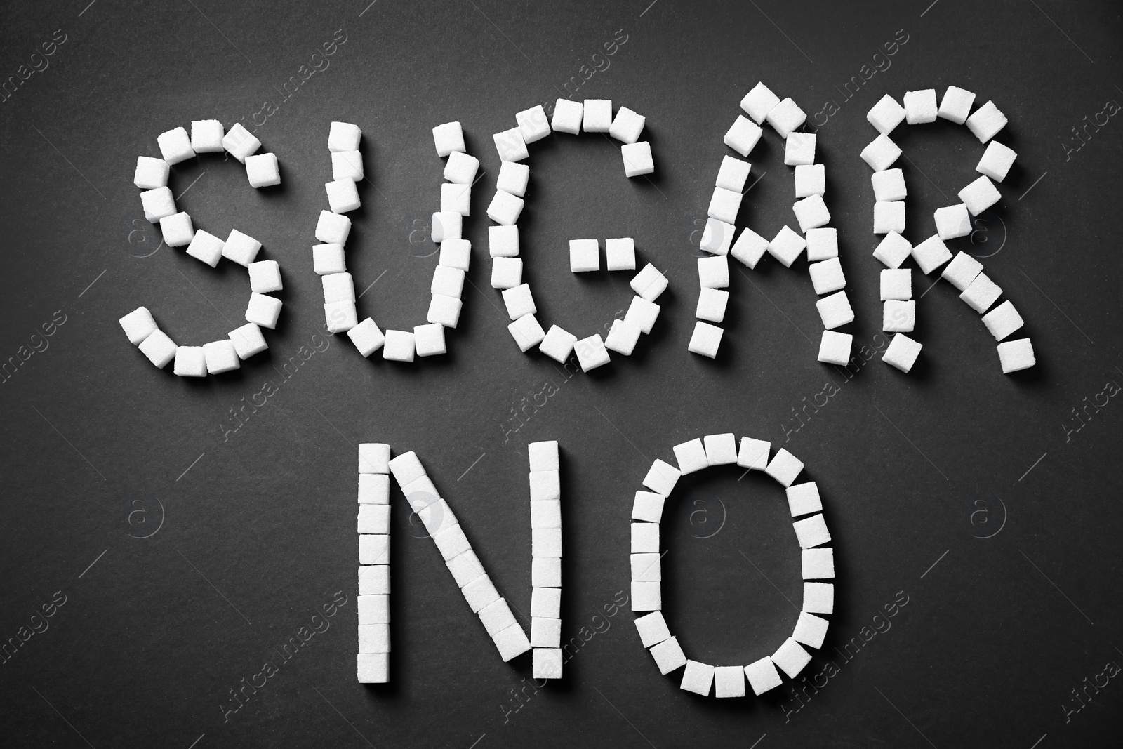 Photo of Phrase NO SUGAR on dark background