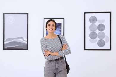 Photo of Happy young woman at exhibition in art gallery