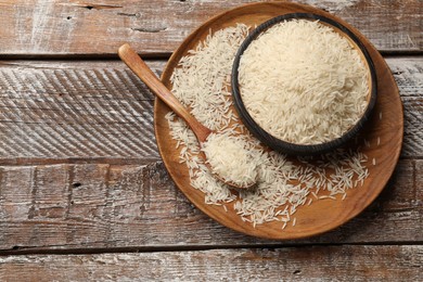Photo of Raw basmati rice on wooden table, top view. Space for text