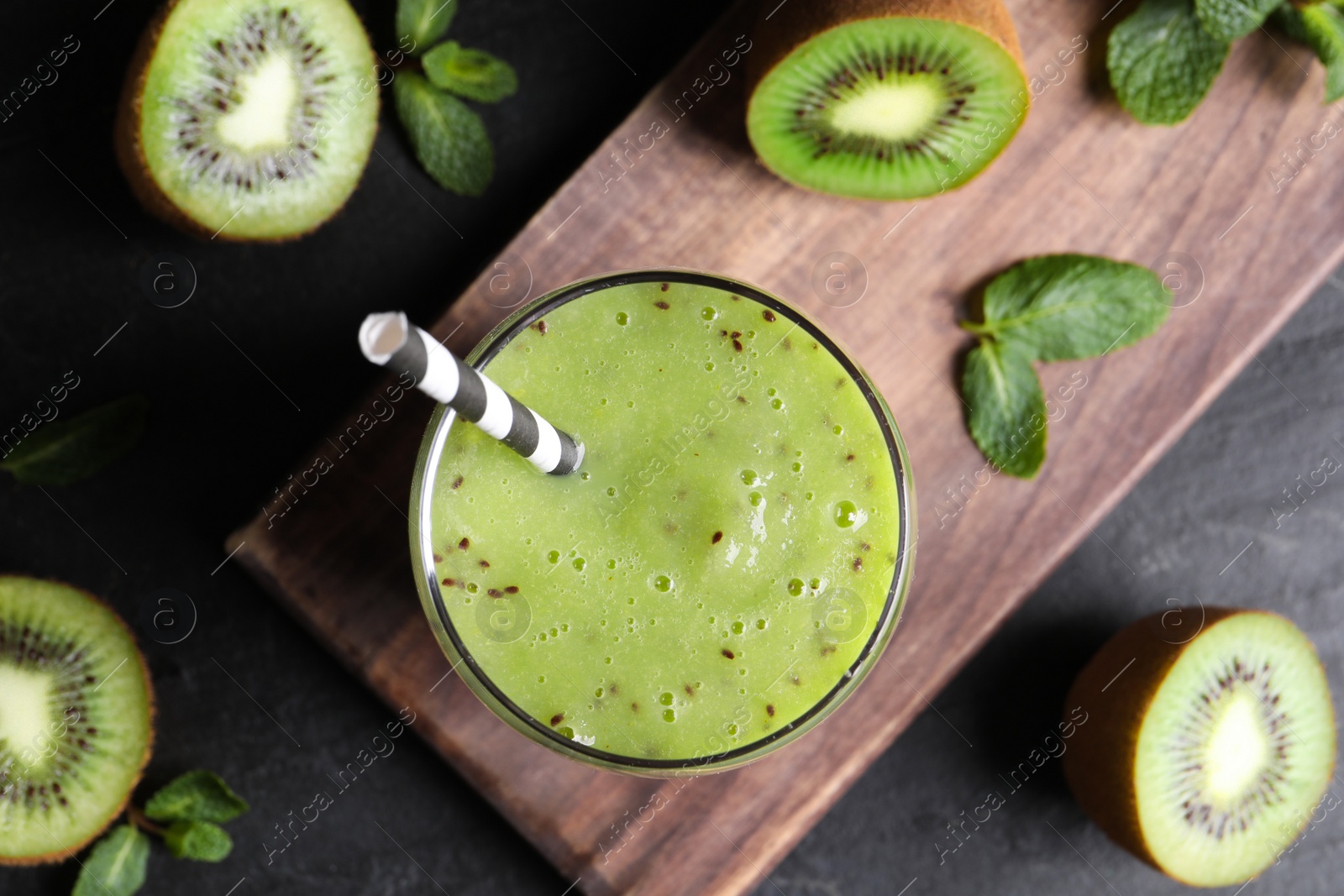 Photo of Delicious kiwi smoothie on black table, flat lay