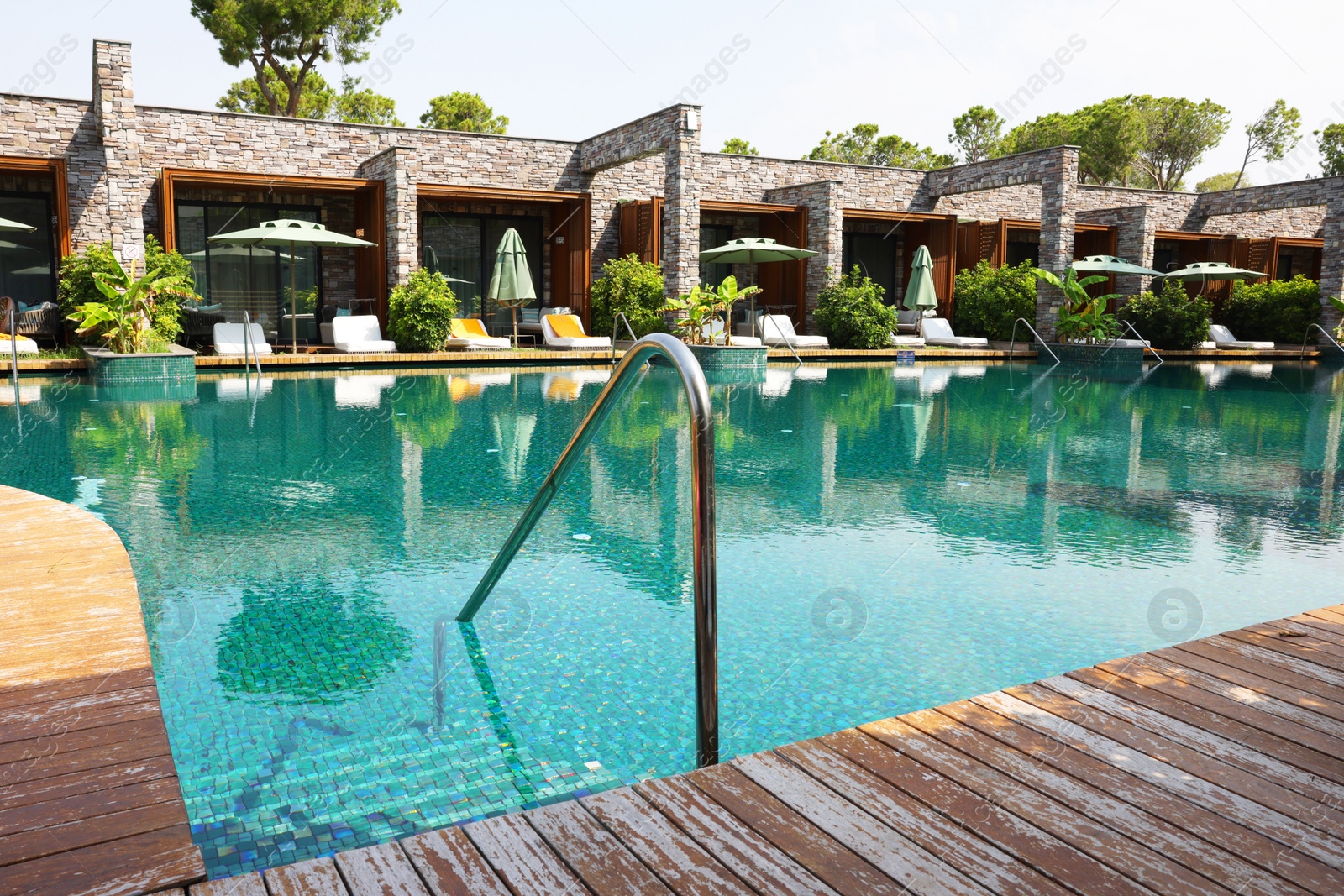 Photo of Outdoor swimming pool with wooden deck and sunbeds at resort