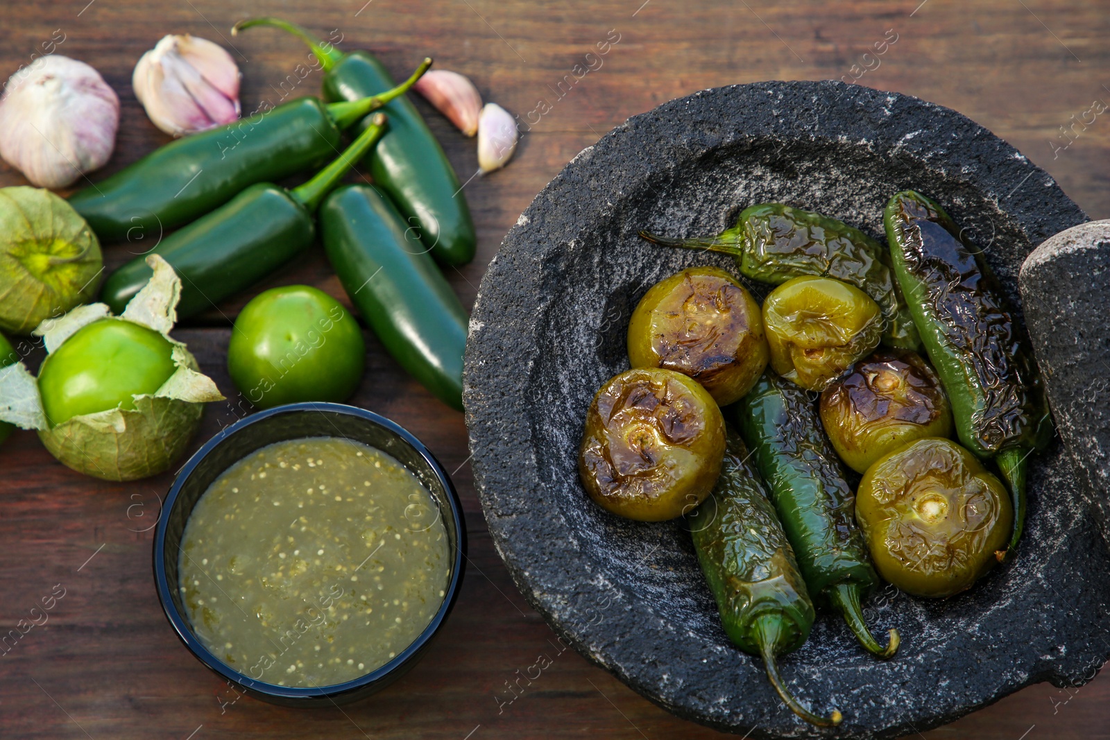 Photo of Different ingredients for cooking tasty salsa sauce on wooden table, above view