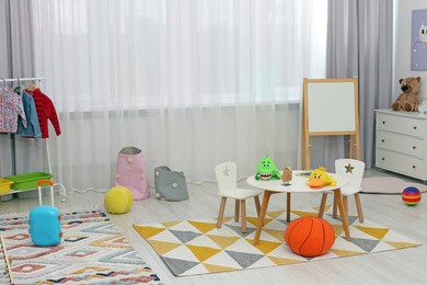 Photo of Child`s playroom with different toys and modern furniture. Stylish kindergarten interior