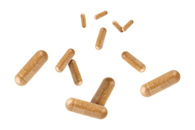 Vitamin. Many capsules falling on white background