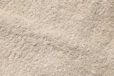 Photo of Texture of soft beige fabric as background, top view