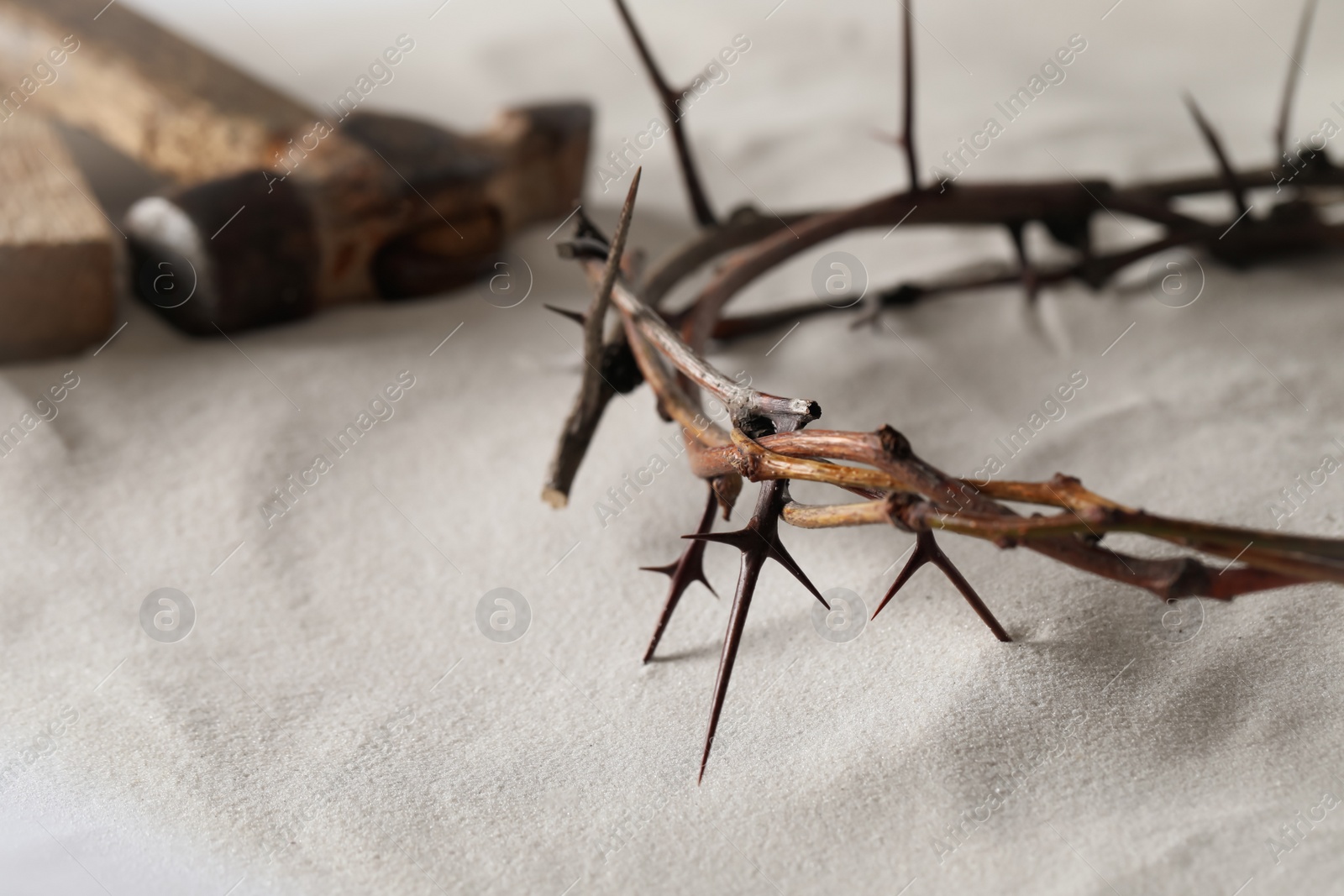 Photo of Crown of thorns on sand, closeup with space for text. Easter attribute