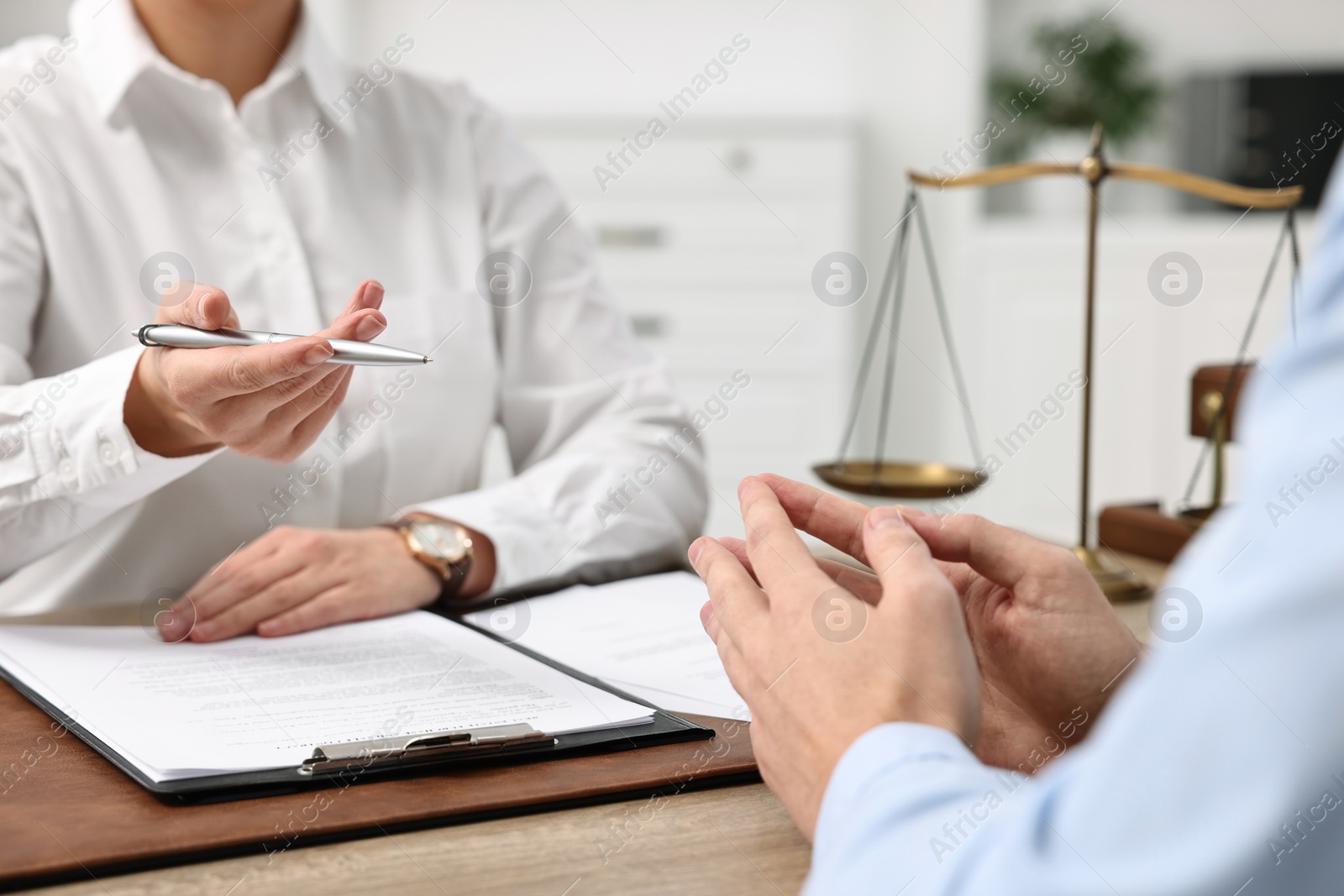Photo of Lawyers working with documents at wooden table in office, closeup