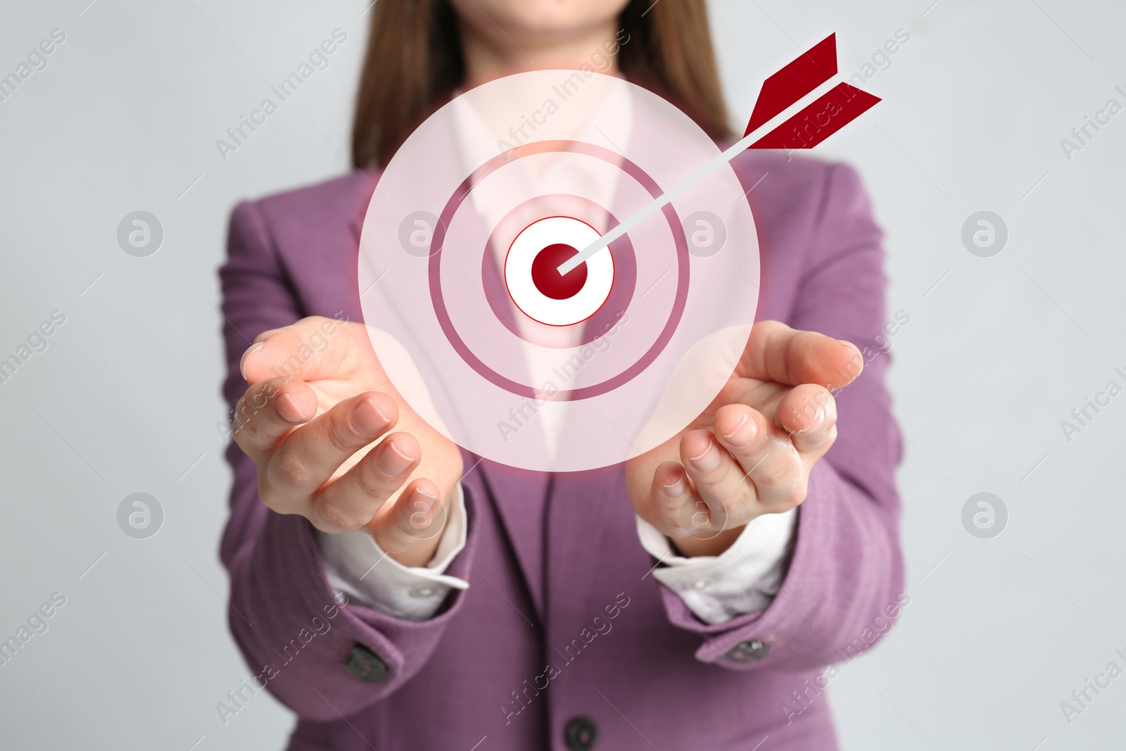 Image of Young woman and dartboard on light background, closeup