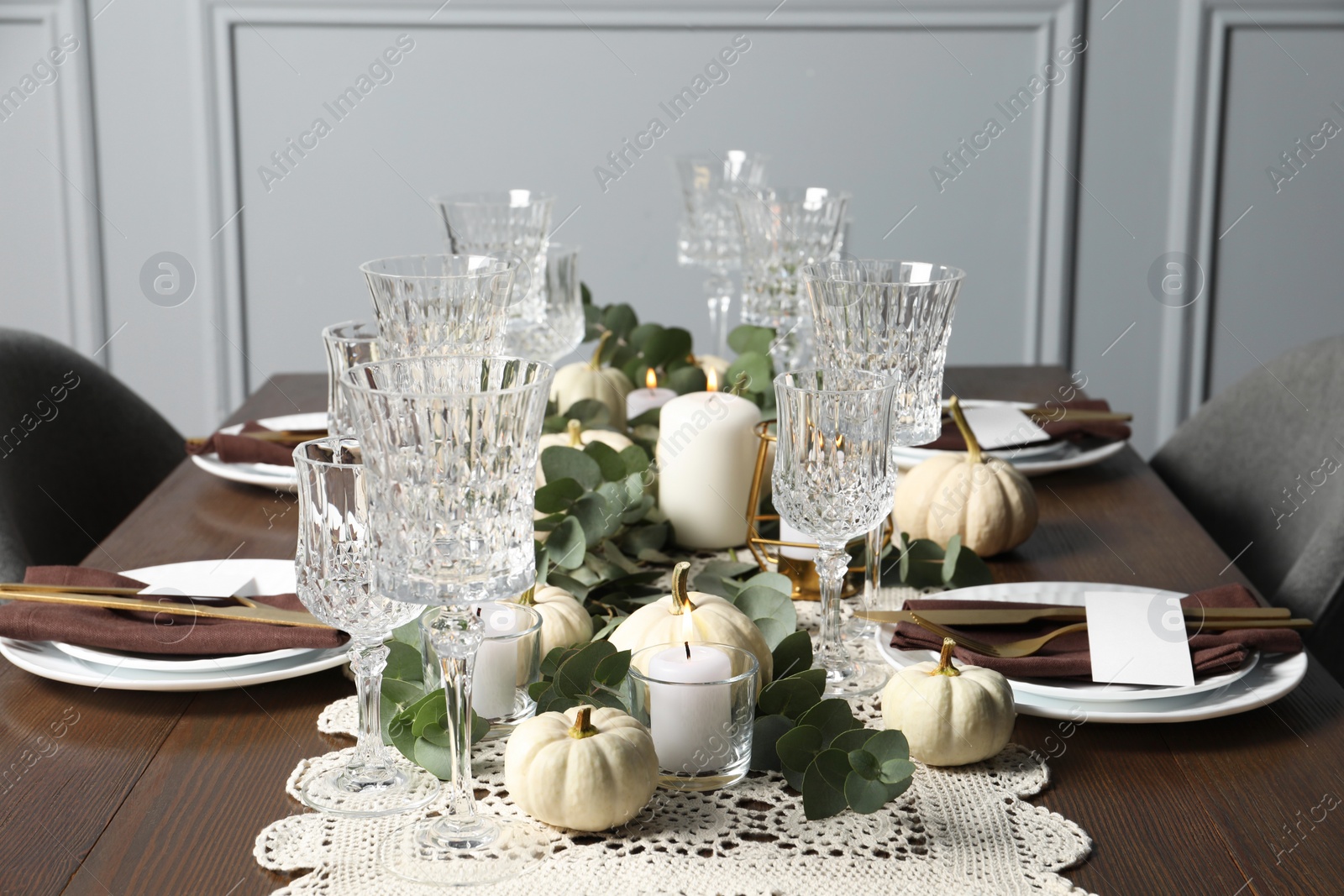 Photo of Beautiful autumn table setting. Plates, cutlery, glasses, blank cards and floral decor