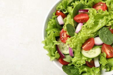 Delicious salad in bowl on light grey table, closeup. Space for text