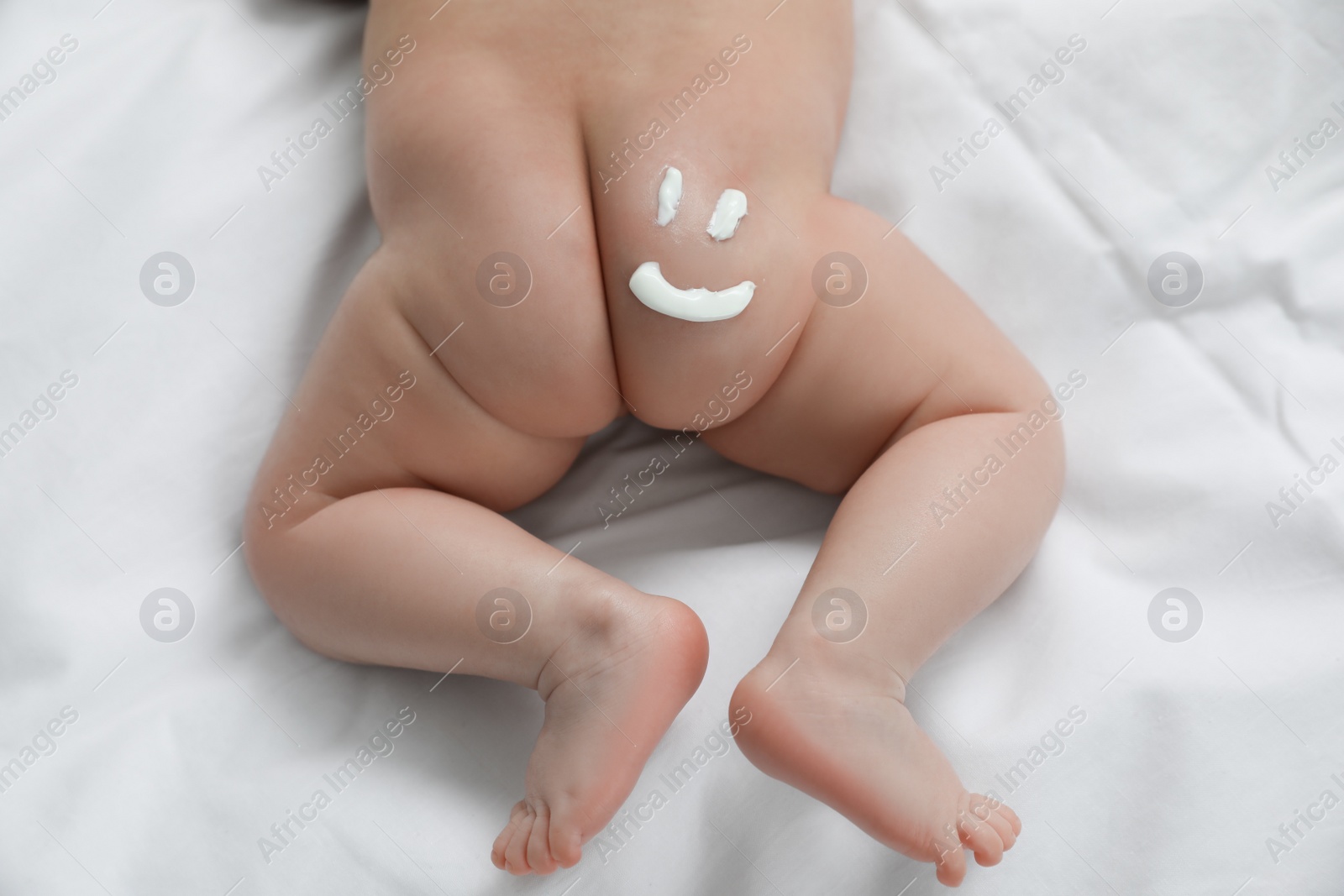 Photo of Cute little baby with cream on body, top view