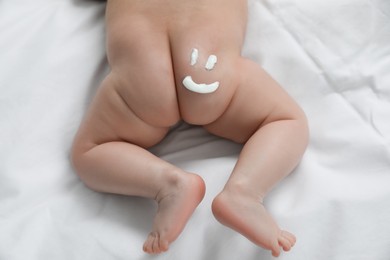 Photo of Cute little baby with cream on body, top view