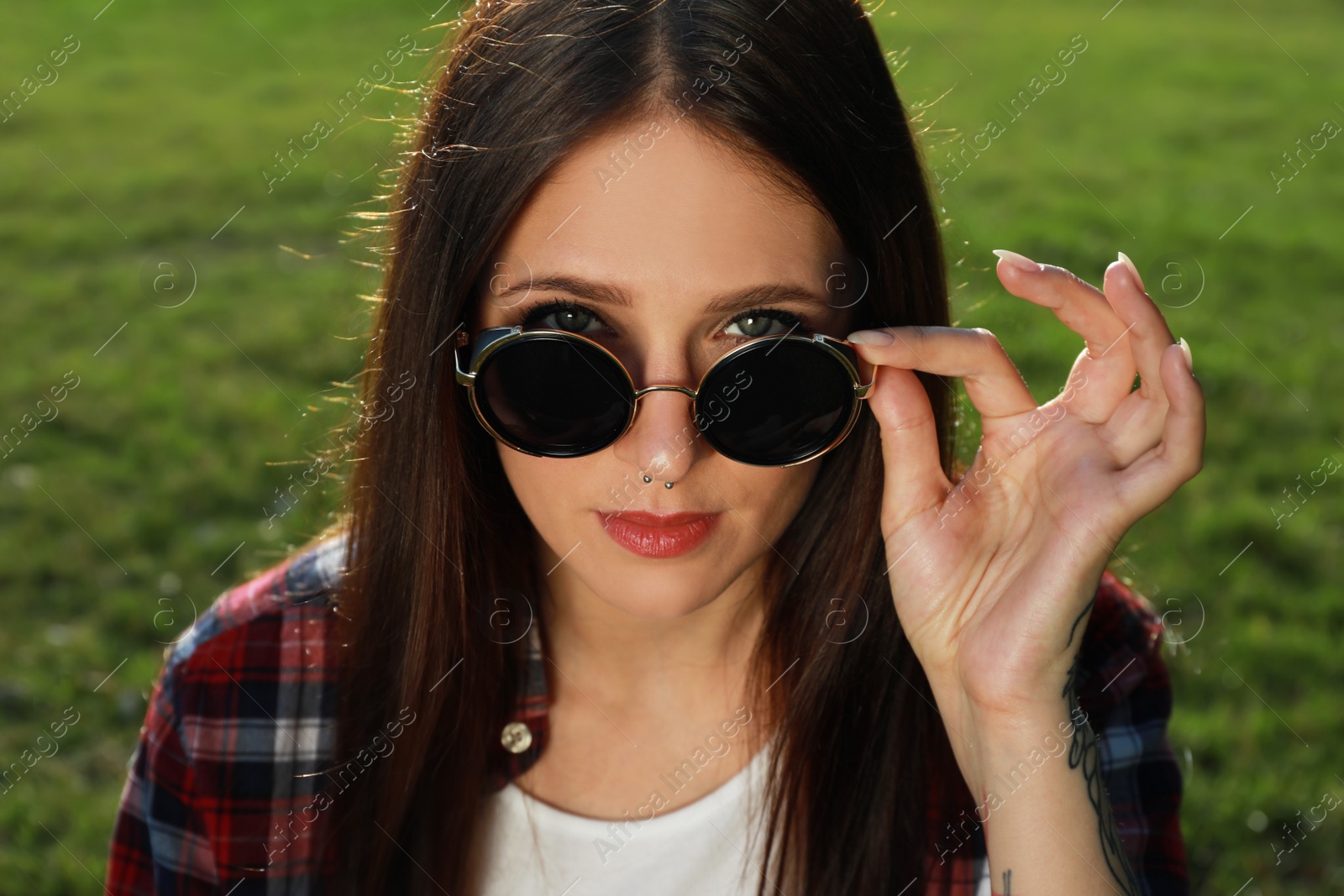 Photo of Beautiful young woman with nose piercing outdoors