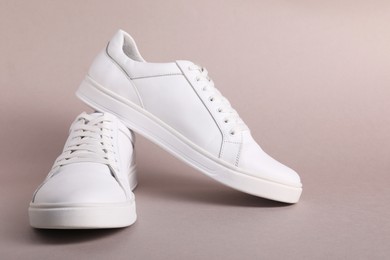 Photo of Pair of stylish white sneakers on grey background