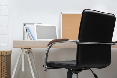 Stylish workplace interior with office chair and wooden table