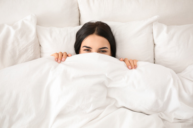 Photo of Young woman awakening at home, top view. Lazy morning