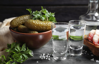 Photo of Cold Russian vodka with snacks on wooden table