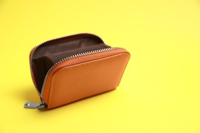 Photo of Stylish brown leather purse on yellow background. Space for text