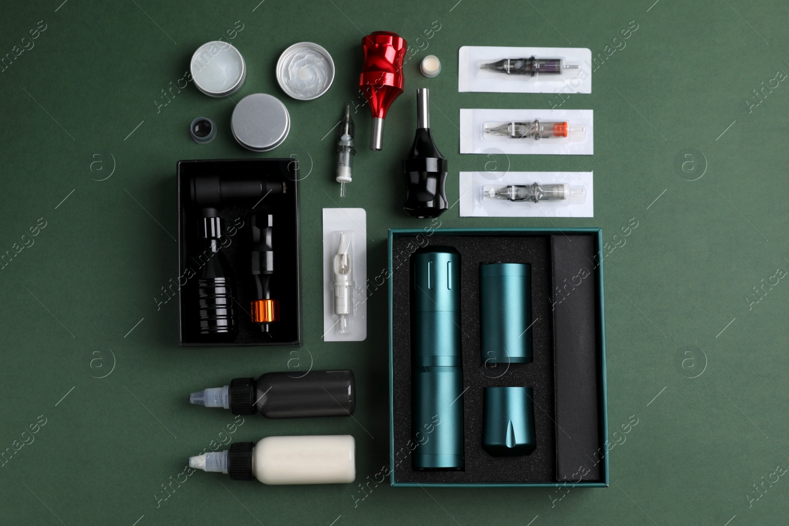 Photo of Flat lay composition with tattoo equipment on dark green background