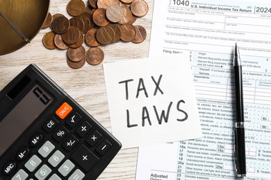 Photo of Tax law. Flat lay composition with paper note and form on wooden table