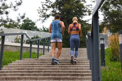 Healthy lifestyle. Couple running up stairs outdoors, back view