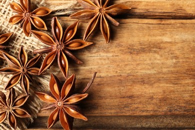 Photo of Aromatic anise stars on wooden table, flat lay. Space for text